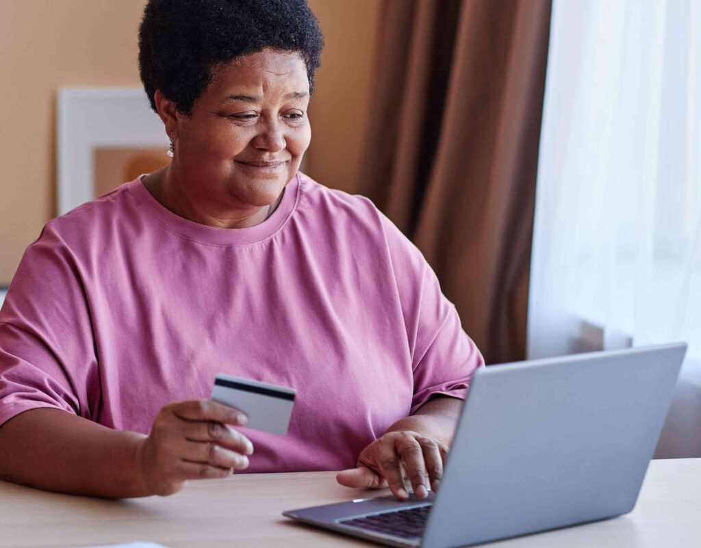 Older lady smiling making a purchase online