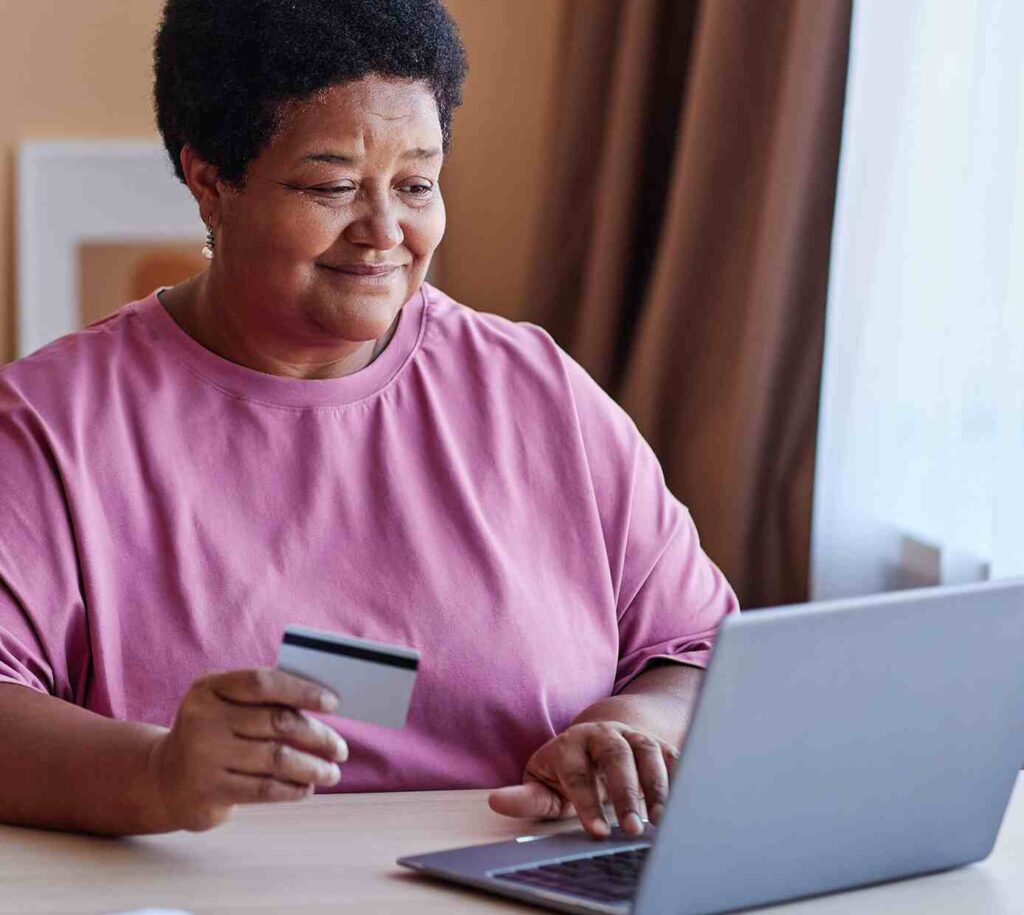Older lady smiling making a purchase online