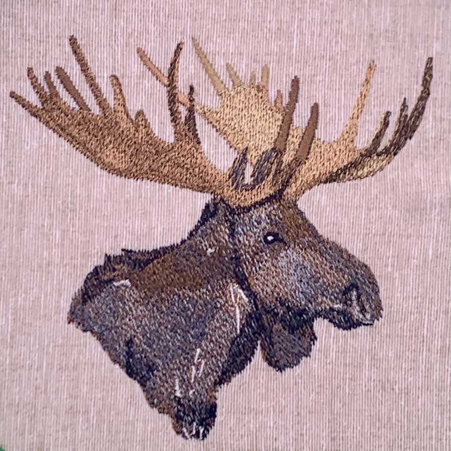 Moose head illustration on pink textured fabric with large antlers, viewed from the side.