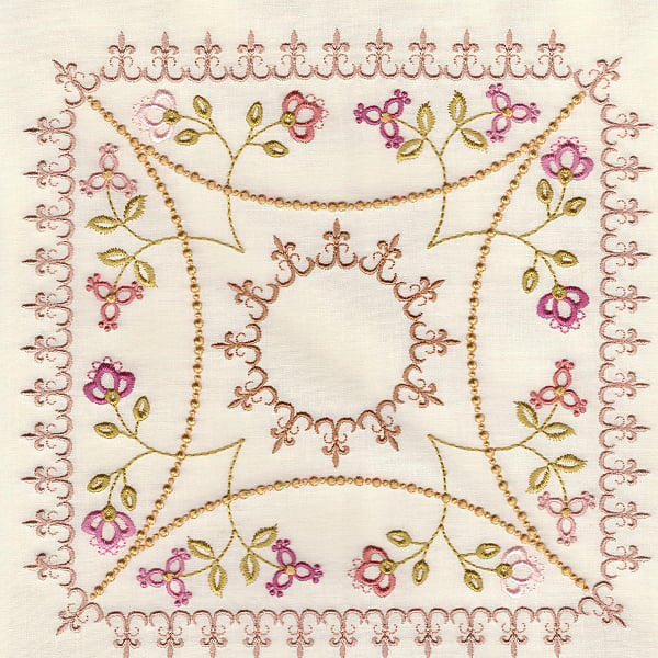 Decorative embroidery on ivory fabric with gold vines, pink flowers, a central sun-like circle, and a scalloped border.