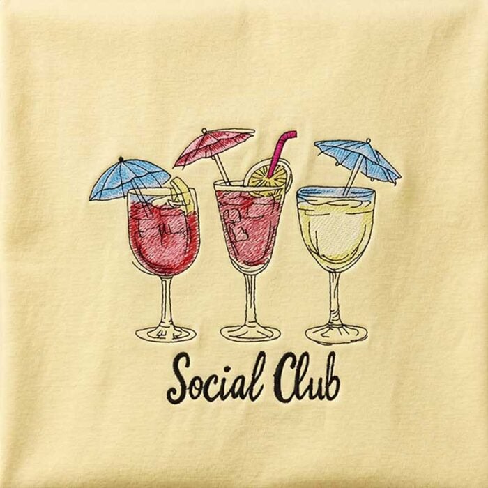 EL-SocialClub_TShirt2 | Embroidery Legacy Three colorful cocktails with small umbrellas on a beige background, with 'Social Club' written underneath.