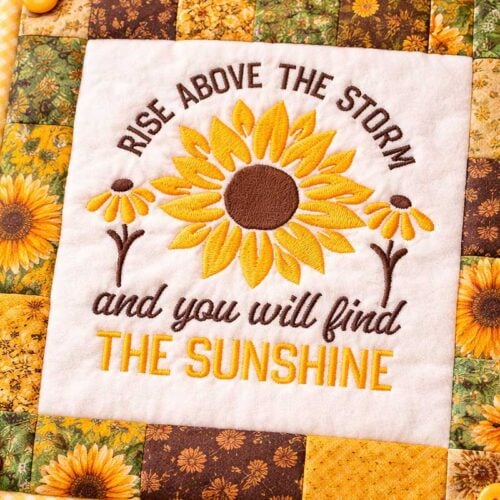 Quilt with sunflower embroidery and inspirational text: “Rise above the storm and you will find the sunshine.”