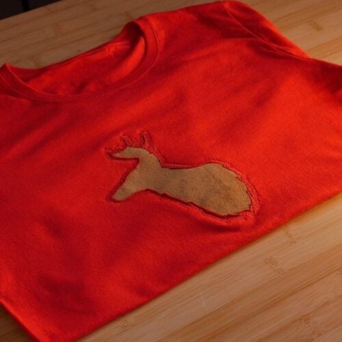 Red T-shirt with a tan rabbit-shaped patch in a worn hole on the chest area