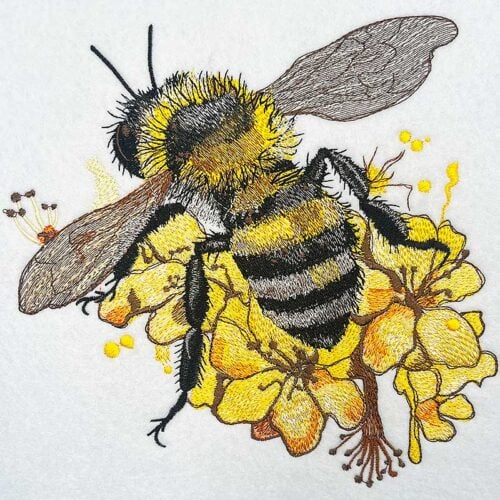 EL-Bee-1_4xl-ftn2bu | Embroidery Legacy Embroidered illustration of a bumblebee perched on bright yellow flowers.
