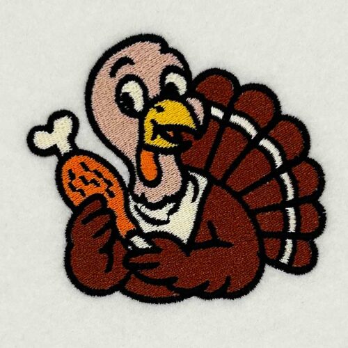 Smiling cartoon turkey holding a roasted drumstick, seen as an embroidered patch on a light background.