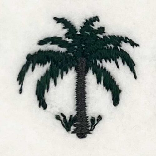 Embroidered palm tree patch on white fabric